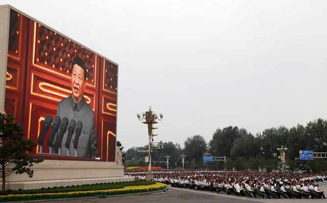 Chinese President Xi Jinping is seen on a giant screen as he delivers a speech at the event marking the 100th founding anniversary of the Communist Party of China, on Tiananmen Square in Beijing, China on July 1, 2021. (Photo by Carlos Garcia Rawlins/Reuters)