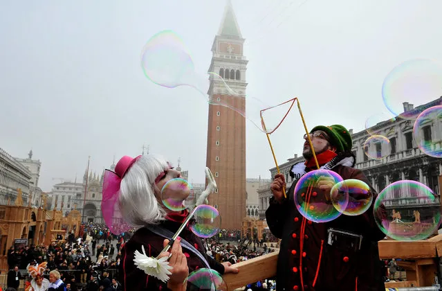 Artists blow bubbles in St. Mark's Square in Venice, Italy, Sunday, January 31, 2016. Carnival-goers in Venice are being asked by police to momentarily lift their masks as part of new anti-terrorism measures for the annual festivities. Police are also examining backpacks and bags and using metal-detecting wands before revelers are allowed into St. Mark's Square, the heart of the Venetian carnival. (Photo by Luigi Costantini/AP Photo)