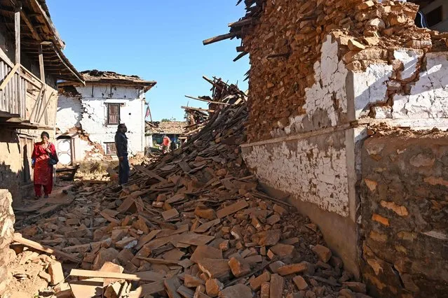 A man looks at damaged houses in the aftermath of an earthquake at Jajarkot district on November 4, 2023. At least 132 people were killed in an overnight earthquake of 5.6-magnitude that struck a remote pocket of Nepal, officials said on November 4, as security forces rushed to assist with rescue efforts. (Photo by Prakash Mathema/AFP Photo)