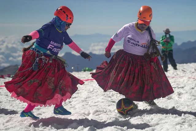 Cecilia Llusco (L) and Senobia Llusco, Aymara indigenous women members of the Climbing Cholitas of Bolivia Warmis, play a football match at about 6.000 m, in the last flat area before making summit at the 6.088-metre Huayna Potosi mountain, near El Alto, Bolivia, on August 14, 2022. The Climbing Cholitas of Bolivia Warmis is a group dedicated to campaigning for the rights of indigenous women through mountaineering. (Photo by Martìn Silva/AFP Photo)