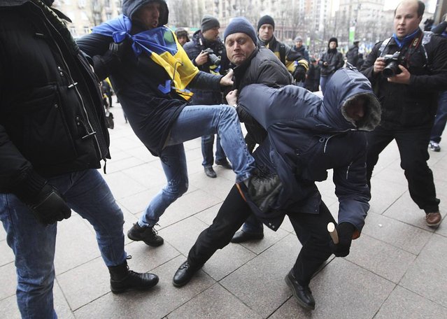 Participants of the rally attack an unidentified man (R, front), treated as a provocateur by the rally organizers, in front of the Kiev City State Administration (Kiev City Council) building during a rally held by supporters of EU integration in Kiev, December 1, 2013. Ukraine's interior minister warned tens of thousands of protesters starting a pro-Europe rally in the capital Kiev on Sunday that police would respond if there were mass disturbances. (Photo by Valentyn Ogirenko/Reuters)