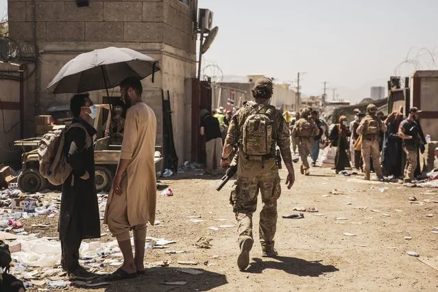 In this image provided by the U.S. Marine Corps, a Canadian coalition forces member walks through an evacuation control checkpoint during ongoing evacuations at Hamid Karzai International Airport, Kabul, Afghanistan, Tuesday, August 24, 2021. (Photo by Staff Sgt. Victor Mancilla/U.S. Marine Corps via AP Photo)