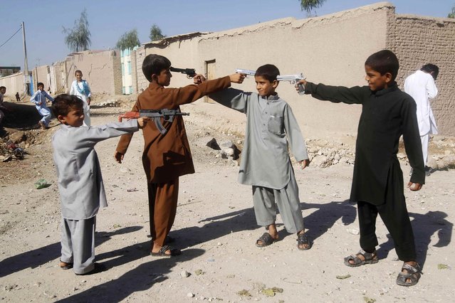 Afghan boys play with toy guns on the first day of Eid al-Adha in Jalalabad October 15, 2013. (Photo by Reuters/Parwiz)