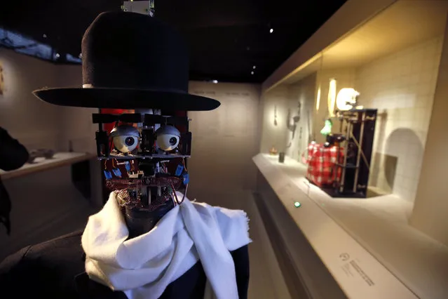 The Berenson robot strolls among visitors during the exhibition “Persona : Oddly Human” at the Quai Branly museum in Paris, France, February 23, 2016. The Berenson robot, developed in France in 2011, is the brainchild of anthropologist Denis Vidal and robotics engineer Philippe Gaussier. Its programming allows it to record reactions of museum visitors to certain pieces of art and then use the data to develop its own unique taste, which allows “Berenson” to judge whether or not it likes a certain work of art within an exhibition. (Photo by Philippe Wojazer/Reuters)