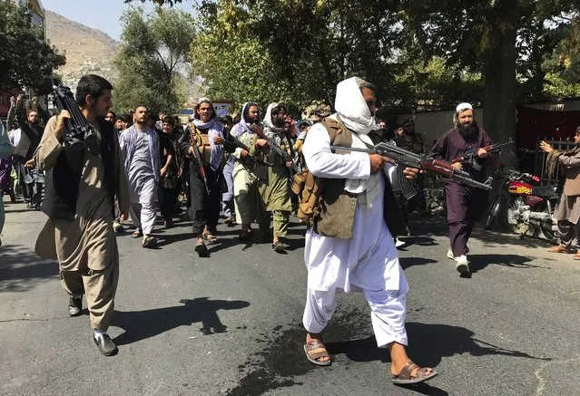 Taliban soldiers walk towards Afghans shouting slogans, during an anti-Pakistan demonstration, near the Pakistan embassy in Kabul, Afghanistan, Tuesday, September 7, 2021. (Photo by Wali Sabawoon/AP Photo)