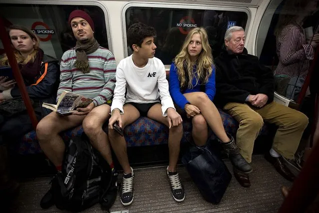 People take part in the No Trousers Tube Ride event next to other passengers on an underground train passing through London. (Photo by Matt Dunham/Associated Press)