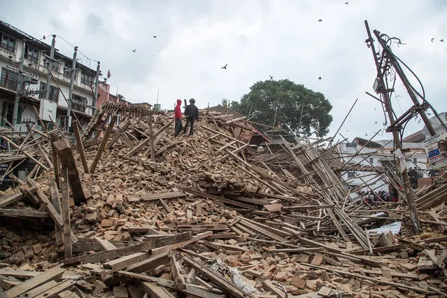 People stand on top of debris from a collapsed building at Basantapur Durbar Square watching the destruction following an earthquake on April 25, 2015 in Kathmandu, Nepal. (Photo by Omar Havana/Getty Images)