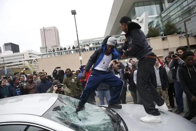 Protesters jump on a car at a rally to protest the death of Freddie Gray who died following an arrest in Baltimore, Maryland April 25, 2015. (Photo by Shannon Stapleton/Reuters)