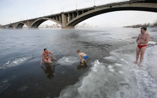 Daniil German (C), 9, a member of a local winter swimming club, goes for a dip in the Yenisei River at temperatures of about –24 degrees Celsius (–11 degrees Fahrenheit) in Russia's Siberian city of Krasnoyarsk, January 27, 2014. (Photo by Ilya Naymushin/Reuters)