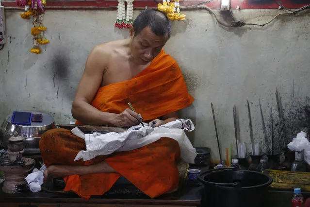 A Buddhist prepares his instruments before tattooing the body of a man at Wat Bang Phra in Nakhon Pathom province on the outskirts of Bangkok, Thailand,  March 18, 2016. (Photo by Chaiwat Subprasom/Reuters)