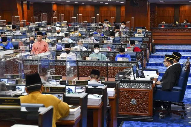 In this photo released by Malaysia's Department of Information, Malaysia's Finance Minister Zafrul Aziz, center left, delivers the 2022 budget speech at parliament in Kuala Lumpur, Malaysia, Friday, October 29, 2021. (Photo by Famer Roheni/Malaysia Department of Information via AP Photo)