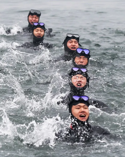 A ship salvage unit of the South Korean Navy sings a martial song in the winter sea during a drill off a naval base in Changwon, South Korea, 18 January 2024. (Photo by Yonhap/EPA)