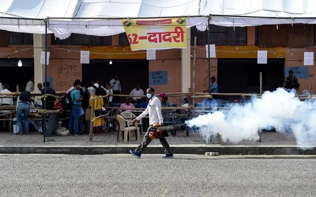 An Indian municipal worker fumigates to get rid of mosquitoes at an election material distribution centre in Noida on April 10, 2019, a day before the beginning of the first phase of India's general election. India is holding a general election to be held over nearly six weeks starting on April 11, when hundreds of millions of voters will cast ballots in the world's biggest democracy. (Photo by Money Sharma/AFP Photo)
