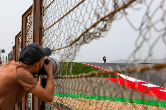 A photographer takes a picture of Miguel Oliveira of Portugal and Trackhouse Racing in action during the second free practice session for the Motorcycling Grand Prix of Portugal, in Portimao, Portugal, 22 March 2024. The 2024 Motorcycling Grand Prix of Portugal is held on 24 March. (Photo by Jose Sena Goulao/EPA)