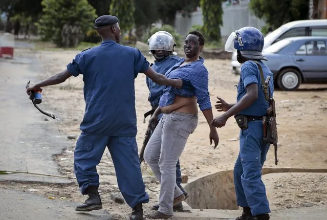 A demonstrator trying to march to the town center is arrested by police, in the Ngagara district of Bujumbura, Burundi Wednesday, May 13, 2015. A police officer opened fire at protesters in Burundi's capital Wednesday as demonstrations against the president's bid for a third term heated up, with troops surrounding the national radio station. (Photo by Gildas Ngingo/AP Photo)