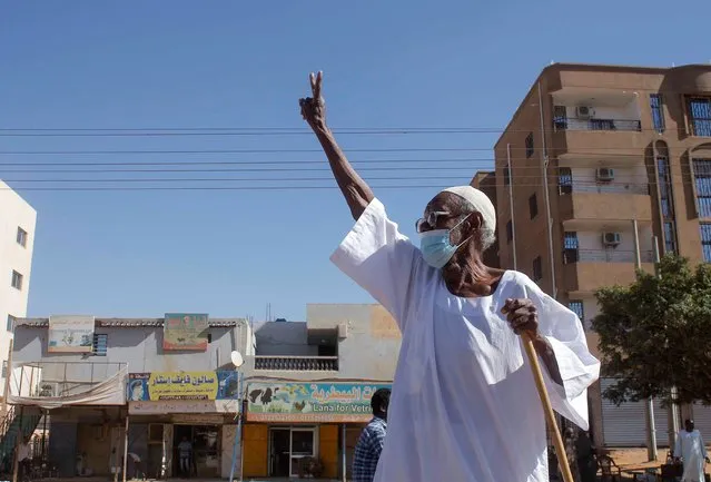 An elderly Sudanese man flashes the victory sign as protesters rally to call for a return to civilian rule in the capital Khartoum, Sudan on November 21, 2021. (Photo by AFP Photo/Stringer)