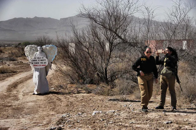 A young woman (L) who is a member of the “Psalm 100” evangelical church, dressed as a messenger of peace angel, calls for justice for women whose bodies were dumped in the Navajo Arroyo, 60 km south of Ciudad Juarez, in the Juarez Valley desert in Chihuahua state, northern Mexico, on February 23, 2017. (Photo by Herika Martinez/AFP Photo)