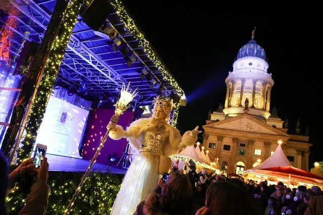 An artist dressed as Ice Queen gestures as people visit a Christmas market, amid the coronavirus disease (COVID-19) pandemic, at Gendarmenmarkt square in Berlin, Germany, November 22, 2021. (Photo by Christian Mang/Reuters)