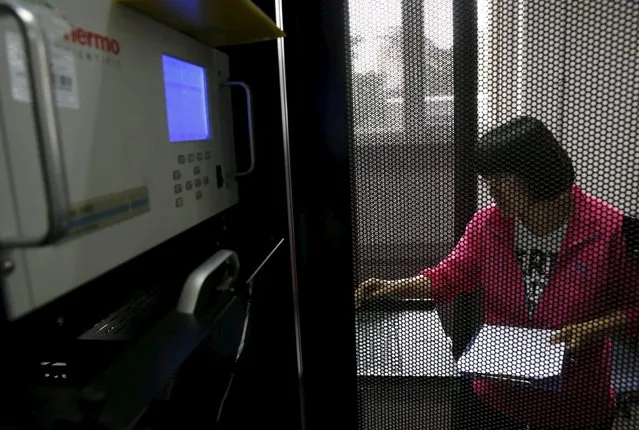 A staff member of the Beijing Municipal Environmental Protection Monitoring Center works with a device for analyzing air quality at the air quality forecast and warning center in Beijing, China, May 21, 2015. (Photo by Kim Kyung-Hoon/Reuters)
