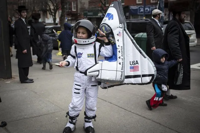 A child dressed as an astronaut stands on a street corner during the Jewish holiday of Purim in the South Williamsburg suburb of New York, on March 17, 2014. (Photo by Andrew Kelly/Reuters)