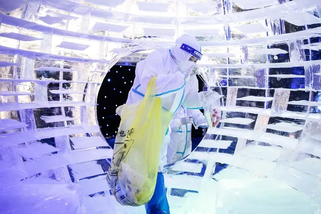 This photo taken on December 21, 2021 shows a health worker collecting samples to be tested for the Covid-19 coronavirus at an ice and snow themed park in Wuhan in China's central Hubei province. (Photo by AFP Photo/China Stringer Network)