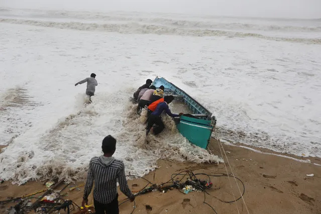 People try to move a fishing boat to a safer ground on the Arabian Sea coast in Veraval, Gujarat, India, Thursday, June 13, 2019. Authorities have evacuated nearly 300,000 people from India's western coastline ahead of a very severe cyclone that's expected to make landfall as the year's second major storm. The India Meteorological Department says Cyclone Vayu, named after the Hindi word for wind, could glance the western state of Gujarat Thursday afternoon before returning to sea. (Photo by Ajit Solanki/AP Photo)