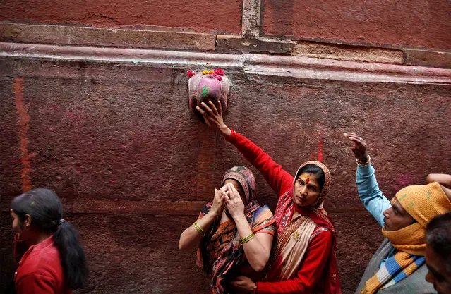 A Hindu devotee touches the outside of a temple as she takes part in the religious festival of Holi in Vrindavan, in the northern state of Uttar Pradesh, India, March 8, 2017. (Photo by Cathal McNaughton/Reuters)