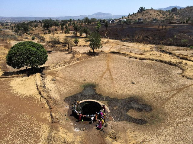 A drone view of women drawing water from a well on a hot day in Kasara, India, on May 1, 2024. (Photo by Francis Mascarenhas/Reuters)