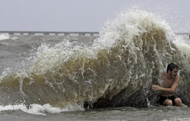 Brady Dayries is hit by a wave as winds from Tropical Storm Barry push water from Lake Pontchartrain over the seawall Saturday, July 13, 2019, in Mandeville, La. (Photo by David J. Phillip/AP Photo)
