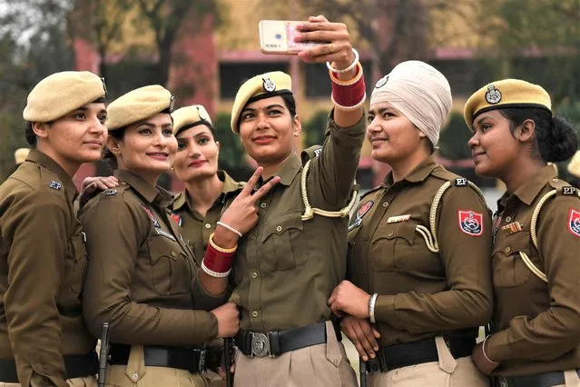 Women police personnel take selfie pictures during a rehearsal for the upcoming Republic Day parade, in Amritsar on January 23, 2022. (Photo by Narinder Nanu/AFP Photo)