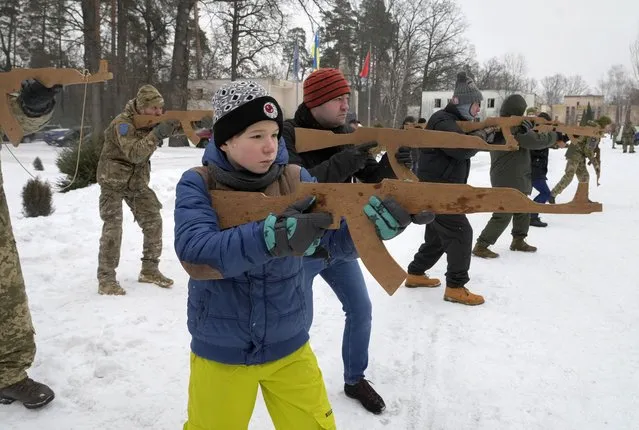 Yuri, 12, trains with members of Ukraine's Territorial Defense Forces, volunteer military units of the Armed Forces, close to Kyiv, Ukraine, Saturday, February 5, 2022. (Photo by Efrem Lukatsky/AP Photo)