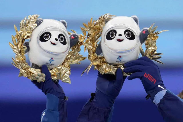 U.S. athletes, members of the silver medalists team, hold up the mascot during a victory ceremony after the team event in the figure skating competition at the 2022 Winter Olympics, Monday, February 7, 2022, in Beijing. (Photo by Natacha Pisarenko/AP Photo)