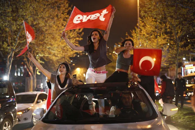 Supporters of the “Yes” vote, wave flags during celebrations in Istanbul, on Sunday, April 16, 2017. With 97 percent of the ballots counted in Turkey's historic referendum, those who back constitutional changes greatly expanding President Recep Tayyip Erdogan's powers had a narrow lead Sunday night, the official Anadolu news agency said. The flags read in Turkish : “Yes”. (Photo by Emrah Gurel/AP Photo)
