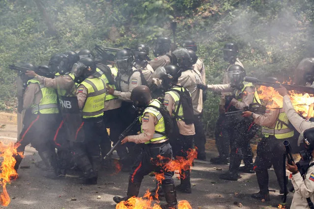 Riot police officers react to fire during a rally against Venezuela's President Nicolas Maduro in Caracas, Venezuela on May 1, 2017. (Photo by Christian Veron/Reuters)