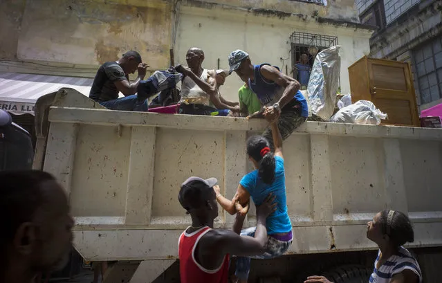 Family members and their belongings are evacuated from their home, for fear the building they live in may collapse, in Havana, Cuba, Friday, July 17, 2015. The family lived next to a building that collapsed Wednesday, where Cuban officials say four people died. A government statement published in Communist Party daily Granma says the two-story residence contained two family homes. (Photo by Ramon Espinosa/AP Photo)