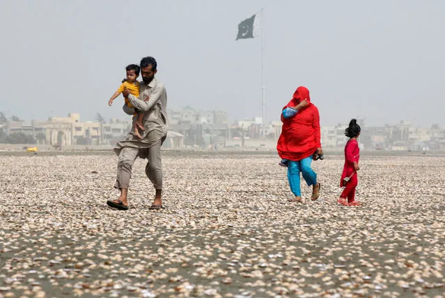 A woman covers her face with scarf to avoid heat while walking with her family along the beach on a hot summer day in Karachi, Pakistan, May 20, 2016. (Photo by Akhtar Soomro/Reuters)