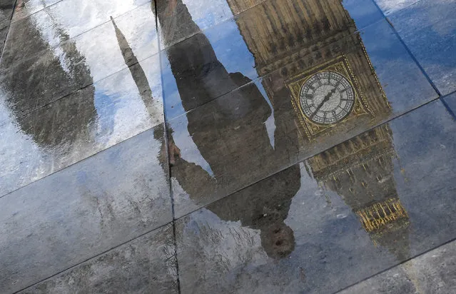 The Elizabeth Tower, commonly known as Big Ben, together with walkers are seen reflected in a puddle in London, England on March 20, 2017. (Photo by Toby Melville/Reuters)