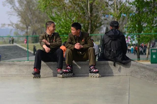 The revealing photographs show North Koreans going about their everyday lives in April 2014. The pictures were taken in Pyongyang, North Korea by freelance photojournalist Gavin John (31) from Calgary, Canada. Here: Two young boys share a laugh at the Pyongyang skate park, where the overwhelming majority of youth were using rollerblades. (Photo by Gavin John/Mediadrumworld.com)