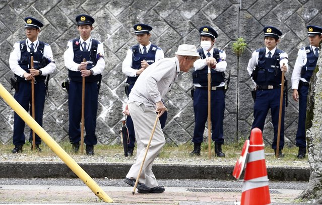 An elderly Japanese man walks in front of policemen near the Ise Jingu shrine ahead of the G7 Ise-Shima Summit in Shima, Mie prefecture, Japan, 25 May 2016. Heads of state and government of the seven leading industriallzed nations (G7) are scheduled to meet at the 42nd G7 summit on 26-27 May 2016 in Shima, Japan. (Photo by Jeon Heon-Kyun/EPA)