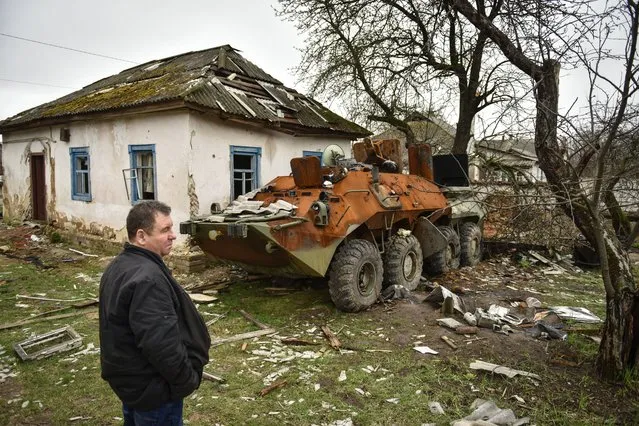 A man observes a burned APC in Yahidne village, Chernihiv region, Ukraine, 19 April 2022 (made available 20 April). On 24 February Russian troops had entered Ukrainian territory resulting in fighting and destruction in the country, a huge flow of refugees, and multiple sanctions against Russia. (Photo by Oleg Petrasyuk/EPA/EFE)