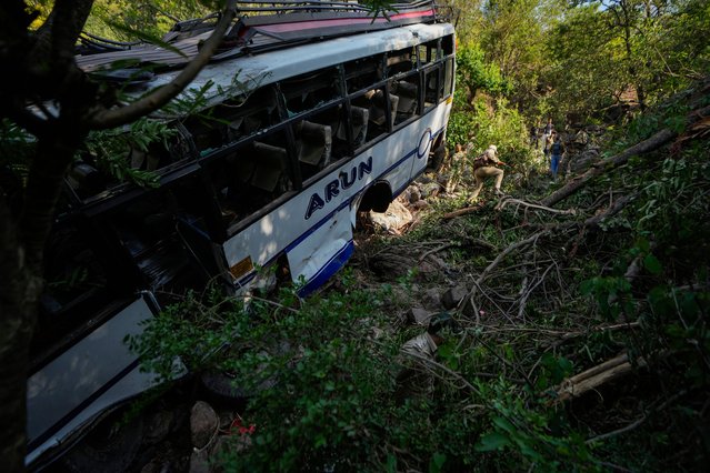 The wreckage of a bus that fell into a deep gorge on Sunday after being fired at by suspected militants in Reasi district, Jammu and Kashmir, Monday, June 10, 2024. The bus was carrying pilgrims to the base camp of the famed Hindu temple Mata Vaishno Devi when it came under attack killing at least nine people. (Photo by Channi Anand/AP Photo)