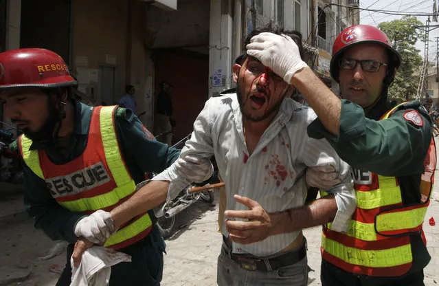 Rescue workers assist an injured supporter of Muhammad Tahirul Qadri, a Sufi cleric and leader of political party Pakistan Awami Tehreek, during a protest in Lahore June 17, 2014. At least eight people including a policeman were killed and dozens wounded in Pakistan on Tuesday when protesters clashed with police in a standoff over a Canada-based anti-Taliban preacher. (Photo by Mohsin Raza/Reuters)