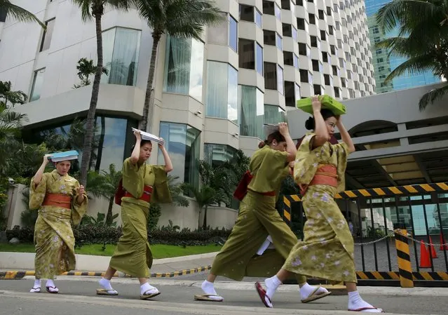 Hotel employees wearing Kimonos evacuate from a building as they participate in the simultaneous earthquake drill in Manila July 30, 2015.. (Photo by Romeo Ranoco/Reuters)