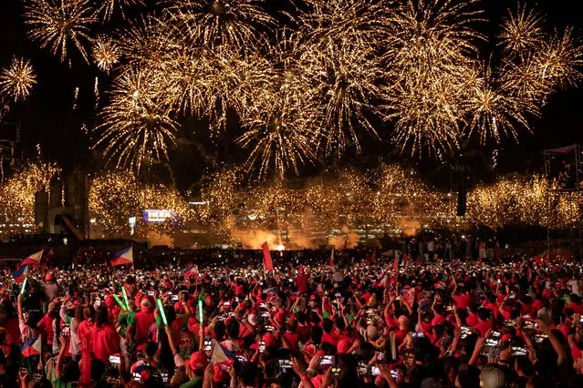 Supporters of presidential candidate Ferdinand “Bongbong” Marcos Jr., the son and namesake of the late Philippine dictator, and vice-presidential candidate Sara Duterte-Carpio, daughter of Philippine President Rodrigo Duterte, watch a fireworks display during the final campaign rally before the 2022 national elections, in Paranaque City, Metro Manila, Philippines, May 7, 2022. (Photo by Eloisa Lopez/Reuters)
