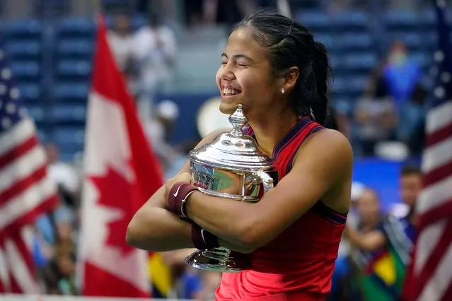 Emma Raducanu, of Britain, hugs the US Open championship trophy after defeating Leylah Fernandez, of Canada, during the women's singles final of the US Open tennis championships, Saturday, September 11, 2021, in New York. (Photo by Elise Amendola/AP Photo)