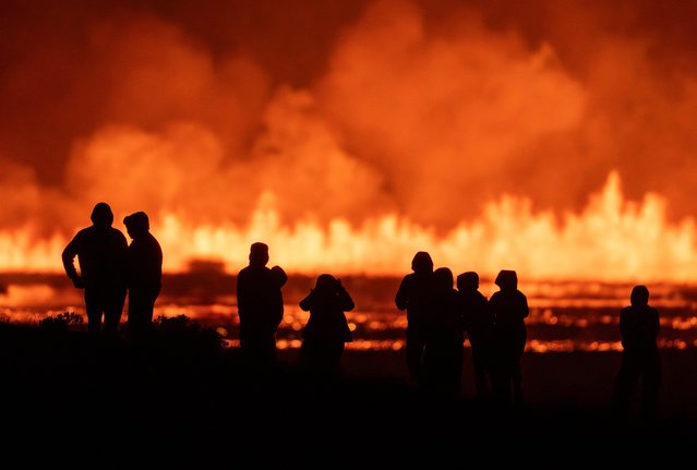 Tourists and visitors try to get a view of the eruption from a distance from the intersection between Reykjanesbraut, Iceland, and the road to Grindavik, Thursday, August 22, 2024. (Photo by Marco di Marco/AP Photo)