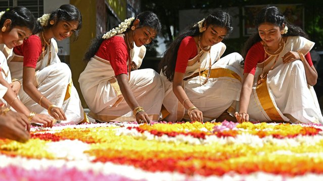 Students prepare a floral decorative design “Rangoli” during the celebrations to mark the annual harvest festival of 'Onam' at a school, in Chennai on September 10, 2024. (Photo by R.Satish Babu/AFP Photo)