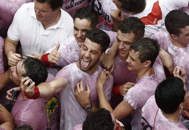 A group of revellers take a “selfie” moments before the rocket fire or “Txupinazo” that marks the start of the Festival of San Fermin (or Sanfermines) in Pamplona, Spain, 06 July 2014. The annual nine day long running-with-the-bulls fiesta commemorates St. Fermin, Pamplona's patron saint. (Photo by Jesus Diges/EPA)
