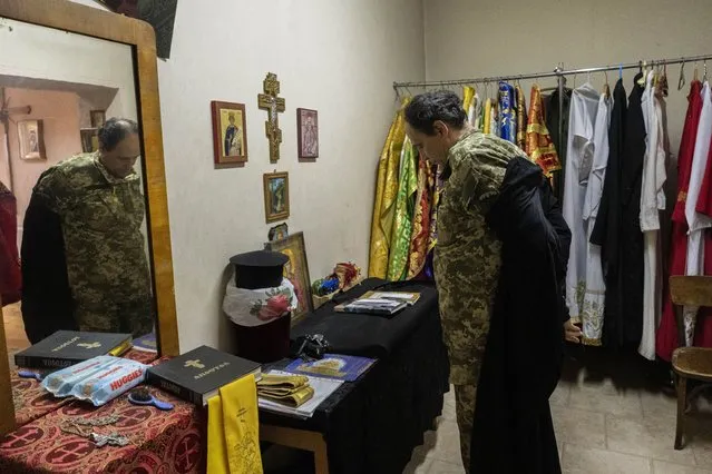 Ukrainian Army Chaplain Vasyl removes his habit after a Sunday mass at a Ukrainian Orthodox church in Kharkiv, eastern Ukraine, Sunday, May 29, 2022. (Photo by Bernat Armangue/AP Photo)