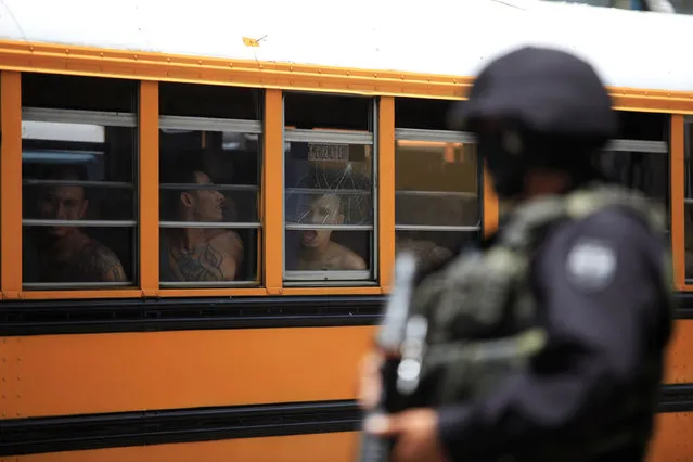 A Salvadoran policeman guards buses as 1282 members of the Barrio 18 gang are transferred from the cojutepeque jail  in Cojutepeque, El Salvador June 16, 2016. (Photo by Jose Cabezas/Reuters)